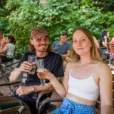 Ein Mann und eine Frau stoßen im Biergarten Hopfen und Salz in Dortmund an.