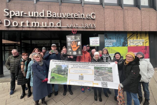 Demonstrierende Mitglieder der Nachbarschaftsinitiative Althoffblock mit einem Transparent vor der Geschäftsstelle des Spar- und Bauvereins.