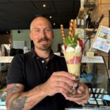 Marcel Knaak, Inhaber vom Hafencafé in Bergkamen, hält einen Eisbecher in die Kamera.