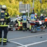 Einsatzkräfte der Feuerwehr Dortmund sind am Unfallort eingetroffen und kümmern sich um die Bergung einer verletzten Person aus einem Pkw. Ein Rettungswagen steht bereit, um die Person zu versorgen.