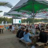 Viele Besucher sitzen am Horstmarer See am Strand vor einer Leinwand.