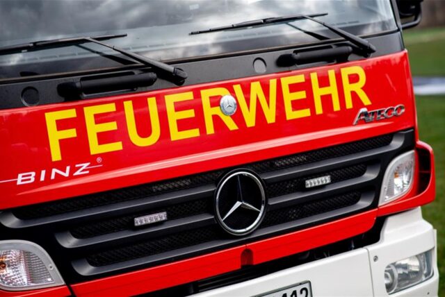 Ein Einsatzfahrzeug der Feuerwehr steht im Rahmen einer Übung auf einem Parkplatz.
