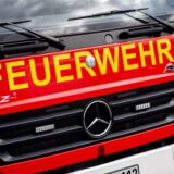 Ein Einsatzfahrzeug der Feuerwehr steht im Rahmen einer Übung auf einem Parkplatz.