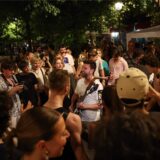 Musikbegeisterte lauschen einem Mann, der während des jährlichen französischen Straßenmusikfestivals „Fete de la Musique“ im 4. Arrondissement von Paris Gitarre spielt.