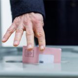 Ein Mann wirft seine Wahlunterlagen in eine Wahlurne.