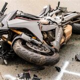 Ein Motorrad liegt nach einem Unfall auf der Fahrbahn. Herumliegende Trümmerstücke deuten auf einen heftigen Zusammenstoß hin.