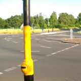 Blick auf die Kreuzung Brackeler Straße, Asselner Straße in Dortmund-Asseln. Schwarz-gelb besprühte Ampelmasten sind zu erkennen, sowie Radfahrer die an die Ampelmasten lehnen.