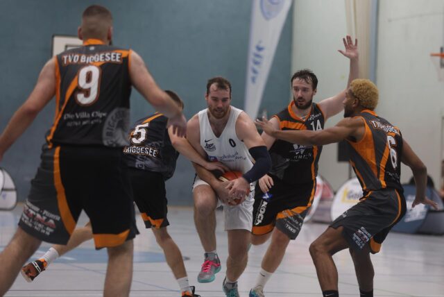 Kevin Bode von den LippeBaskets Werne setzt sich gegen vier Spieler von TVO Biggesee durch.