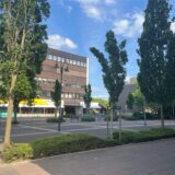 Das Ärztehaus am Zentrumsplatz in der Stadtmitte von Bergkamen. Um eine gepflasterte Fläche stehen vereinzelte Bäume.