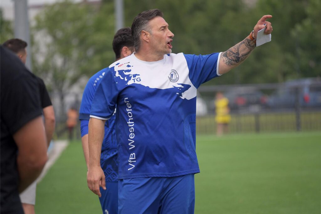 Ein Trainer am Spielfeldrand gibt Anweisungen. Ein Trainer am Spielfeldrand gibt Anweisungen.
