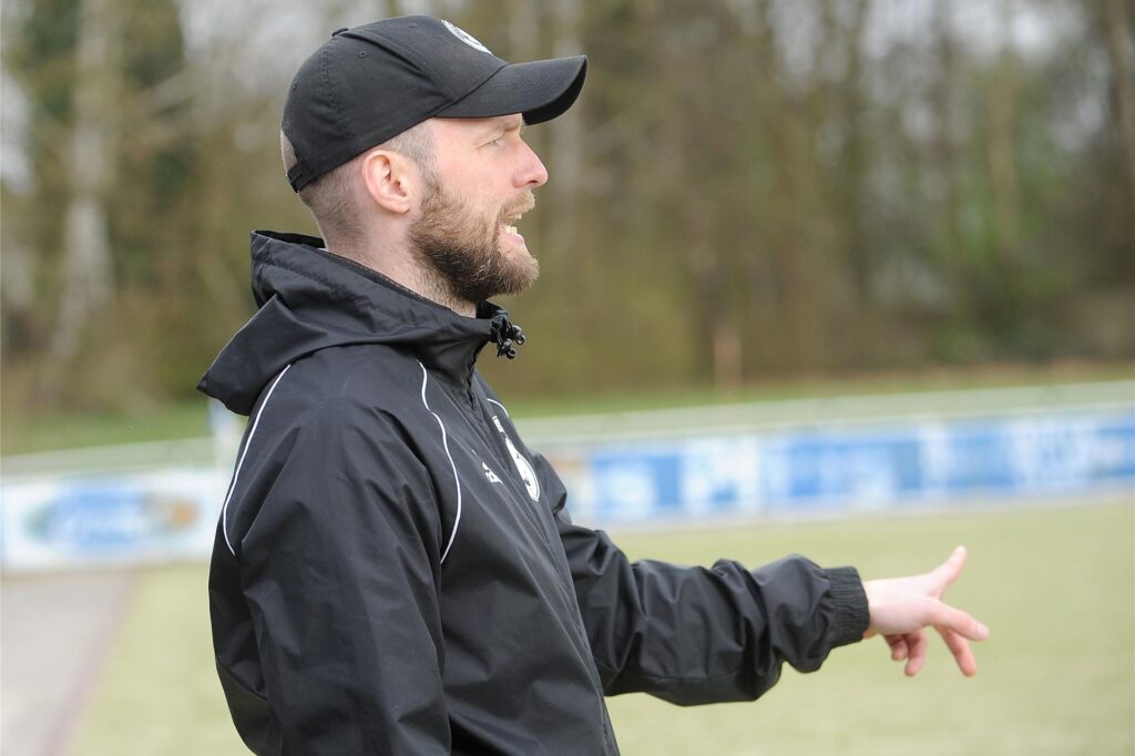 Ein Trainer am Spielfeldrand gibt einen Fingerzeig. Ein Trainer am Spielfeldrand gibt einen Fingerzeig.