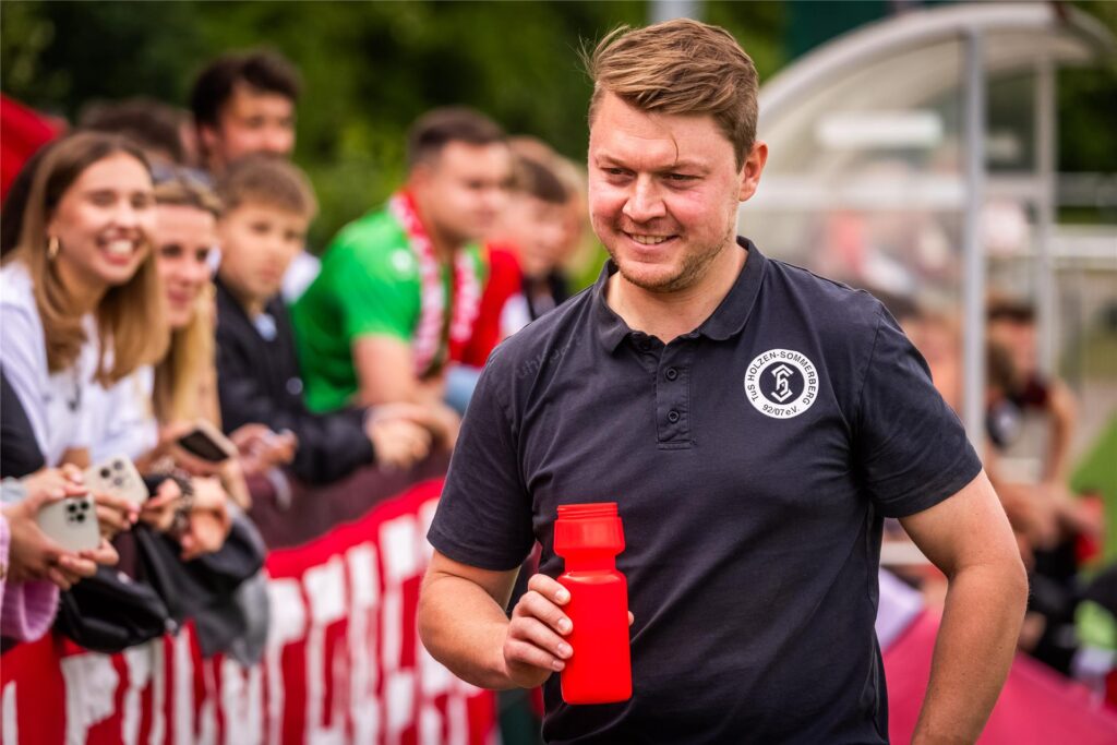 Ein Trainer mit Trinkflasche am Spielfeldrand. Ein Trainer mit Trinkflasche am Spielfeldrand.