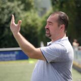 Ein Trainer gestikuliert am Spielfeldrand.