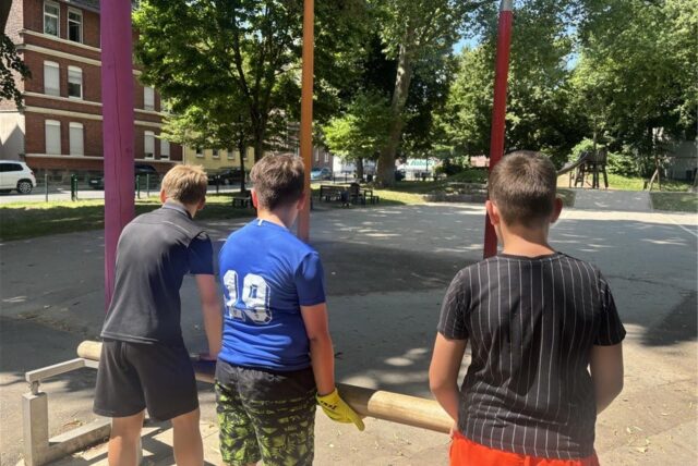 Drei Jungen betätigen die Pumpe am großen Wasserspiel auf dem Wasserspielplatz an der Ruhrstraße in Schwerte.