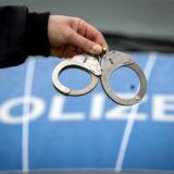 Ein Polizist hält ein Paar Handschellen.