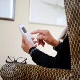 Eine ältere Dame nimmt in ihrer Wohnung ein Telefongespräch an.