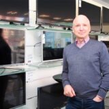 Peter Schiefelbein steht vor Regalen mit Fernsehern in seinem ehemaligen Elektrofachgeschäft in Dortmund-Marten.