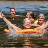 Mehrere Menschen schwimmen im Naturfreibad Heil in Bergkamen.