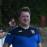 Björn Ziegert steht an der Seitenlinie und lacht
