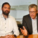 Bergkamens Bürgermeister Bernd Schäfer (rechts) und der Technische Beigeordnete Jens Toschläger sitzen an einem Tisch. Im Hintergrund ist eine Grafik des IGA-Geländes zu sehen.