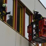 Ein Feuerwehrmann erreicht bei einer Übung in Unna ein Fenster des Schulzentrums Nord in einem Korb.