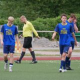 Spieler und Linienrichter stehen auf dem Platz.