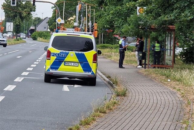 Ein Polizeiauto steht am Kamen Karee, Polizisten sprechen mit zwei Personen an einer Bushaltestelle.