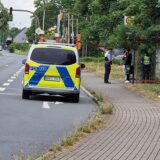 Ein Polizeiauto steht am Kamen Karee, Polizisten sprechen mit zwei Personen an einer Bushaltestelle.