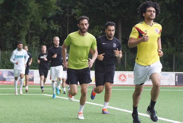 Fußballspieler laufen Runden um den Platz.