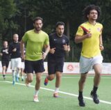 Fußballspieler laufen Runden um den Platz.
