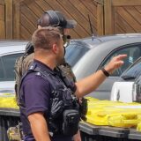 Vor einem weißen Mehrfamilienhaus führen Polizisten eine Bewohnerin ab, die sich der Zwangsräumung widersetzt hatte.