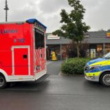 Auf einem Parkplatz stehen ein Rettungs- und ein Polizeiwagen.