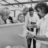 Ein Schwarz-Weiß-Bild. Prof. Lothar Kampmann fertigt beim 5. Bergkamener Bilder Basar (BBB) 1980 eine Skulptur an, drei Frauen und zwei Männer schauen zu.