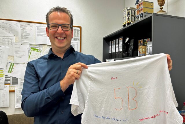 Thorsten Kluger hält ein weißen, bemaltes T-Shirt hoch.