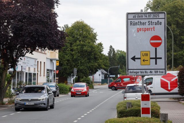 Straßenszene in Bergkamen mit Hinweisschild zur Sperrung der Rünther Straße ab dem 14.07.2025; Autos fahren auf offener Fahrbahn, Umleitung ist ausgeschildert.