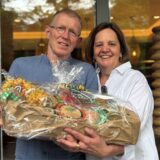 Hagen und Stephanie Lemke stehen mit einem Präsentkorb vor dem Café Köhle in Schwerte.