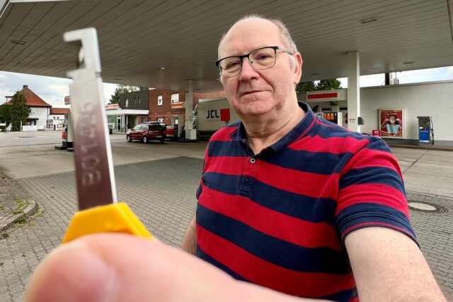 Heribert Neuhaus aus Unna zeigt einen Schlüssel für sein Postfach auf dem Gelände einer Tankstelle.