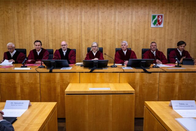 Richterinnen und Richter des Verfassungsgerichtshofs NRW sitzen auf der Richterbank in Münster.