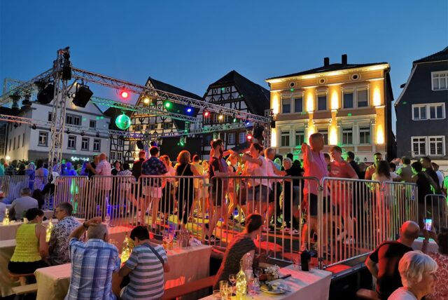 Viele Menschen tanzen abends unter freiem Himmel auf dem Marktplatz in Unna