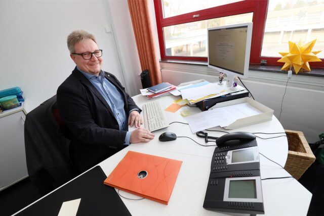 Lars Wollny leitet das Kamener Gymnasium. Hier sitzt er an seinem Schreibtisch.