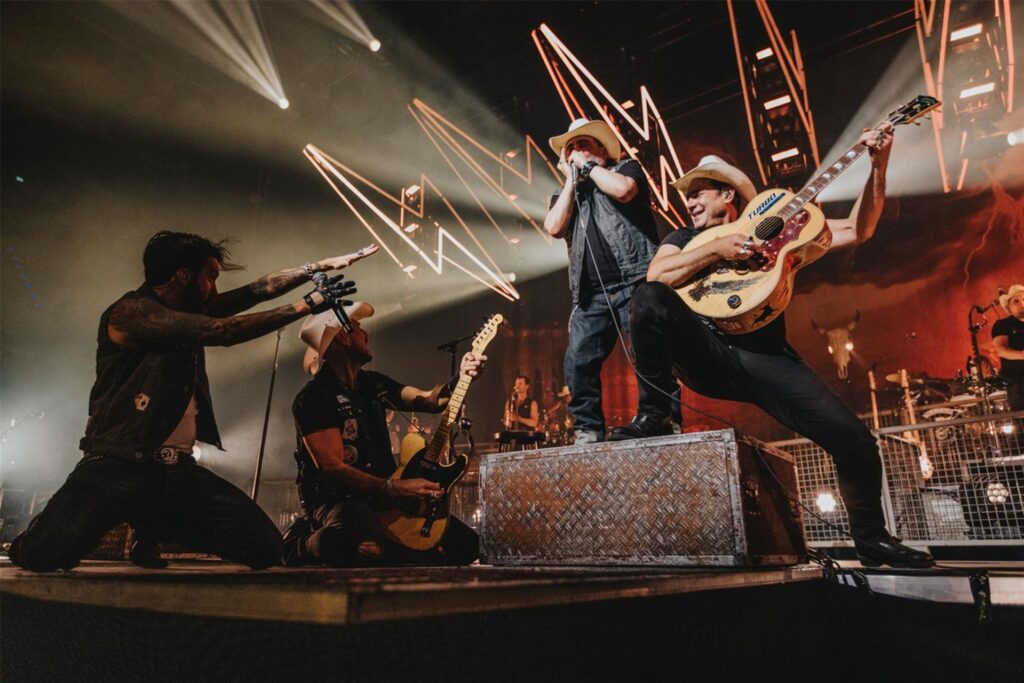 Die Band The BossHoss steht bei einem Auftritt auf der Bühne. Sie tragen Cowboyhüte und halten Gitarren in der Hand. Die Band The BossHoss steht bei einem Auftritt auf der Bühne. Sie tragen Cowboyhüte und halten Gitarren in der Hand.