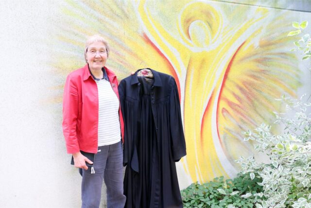Pfarrerin Verena Mann aus Kamen-Methler hält einen Talar in die Höhe. Verena Mann ist nun im Ruhestand. Die Suche nach einem Nachfolger läuft.