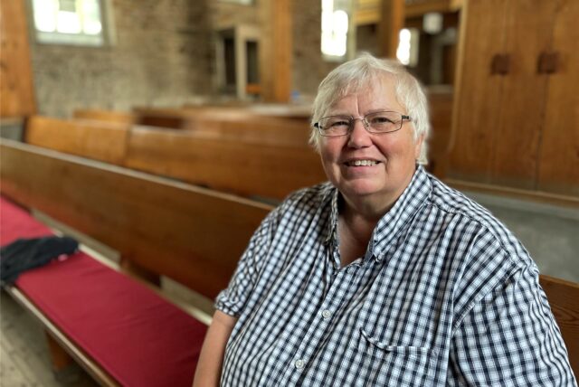 Bettina Wirsching, ehemalige Pfarrerin der evangelischen Christus-Kirchengemeinde im Dortmunder Westen, sitzt in einer der Kirchenbänke in der Bartholomäuskirche in Lütgendortmund.