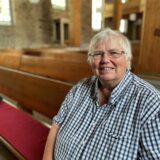 Bettina Wirsching, ehemalige Pfarrerin der evangelischen Christus-Kirchengemeinde im Dortmunder Westen, sitzt in einer der Kirchenbänke in der Bartholomäuskirche in Lütgendortmund.
