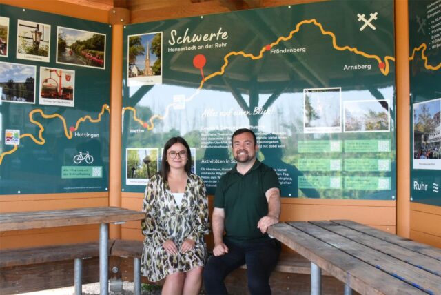 Angelika Goczol, Projektmanagerin der Tourismusförderung im Stadtmarketing Schwerte, und Bürgermeister Dimitrios Axourgos sitzen in der Rasthütte am Ruhrtalradweg in Schwerte