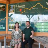 Angelika Goczol, Projektmanagerin der Tourismusförderung im Stadtmarketing Schwerte, und Bürgermeister Dimitrios Axourgos sitzen in der Rasthütte am Ruhrtalradweg in Schwerte