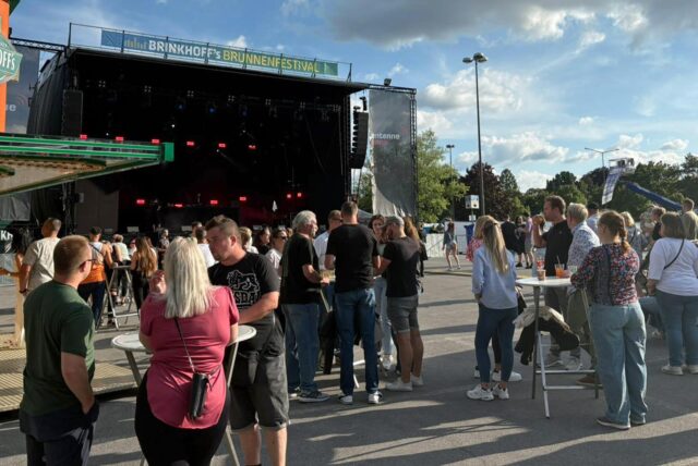 Menschen stehen beim Brunnenfestival in Lünen vor der Hauptbühne.