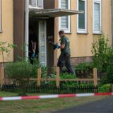 Ermittler der Polizei betreten ein Wohnhaus. Die Polizei Dormagen fand am Freitagnachmittag in einer Wohnung eine 37-jährige Tote. Wenig später nahm sie einen 17-Jährigen fest – es ist der Sohn der Frau.