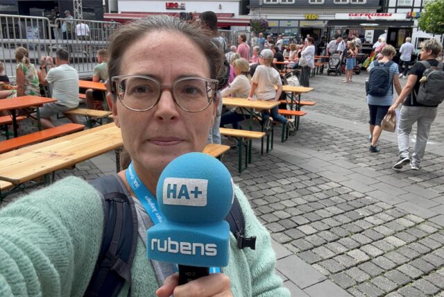 HA-Reporterin Bettina Hesse steht mit Mikro in der Hand auf dem Marktplatz in Unna bei der Tanzparty