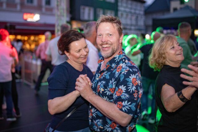 Besucher der Tanzparty tanzen auf der Bühne auf dem Marktplatz in Unna